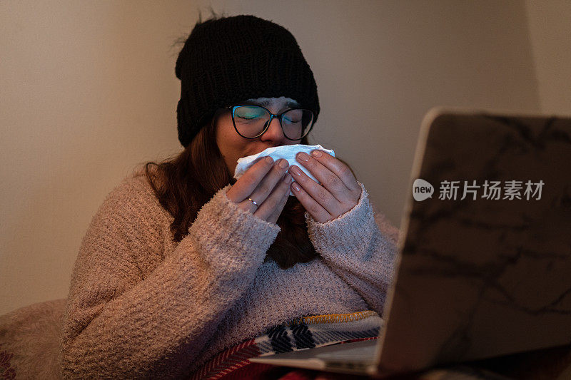 一个年轻女人在卧室里用纸巾打喷嚏