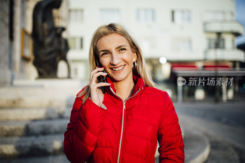 年轻的白种金发女人在用智能手机打电话