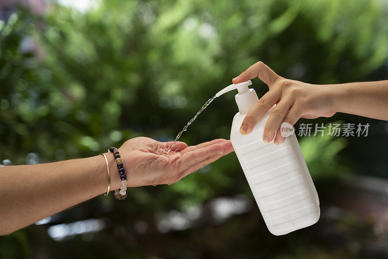 手在男人的手上喷射抗菌洗手液