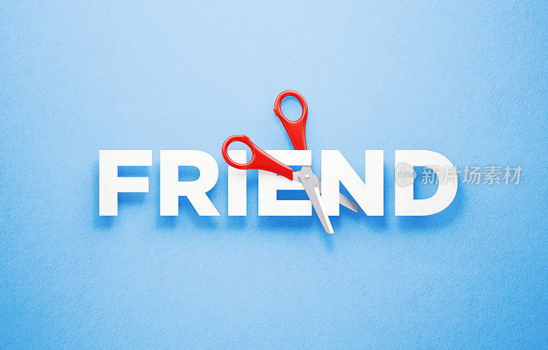 切割友谊和社会隔离概念-剪刀切割字的朋友在蓝色的背景