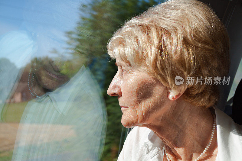 白人老妇人看着窗外的火车