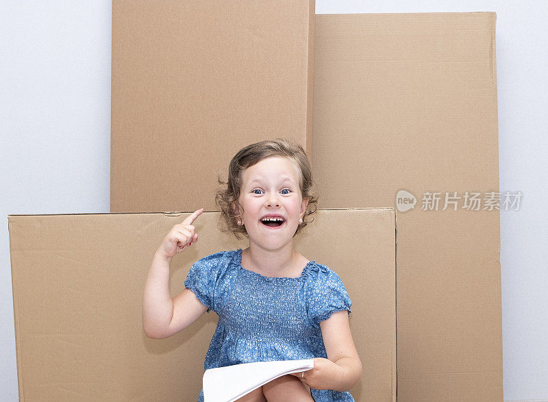 白人女孩6岁大背景下的大纸箱，情感，新想法。