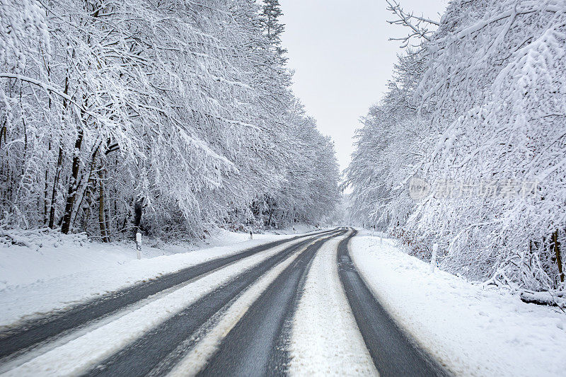 穿过森林的白雪覆盖的道路