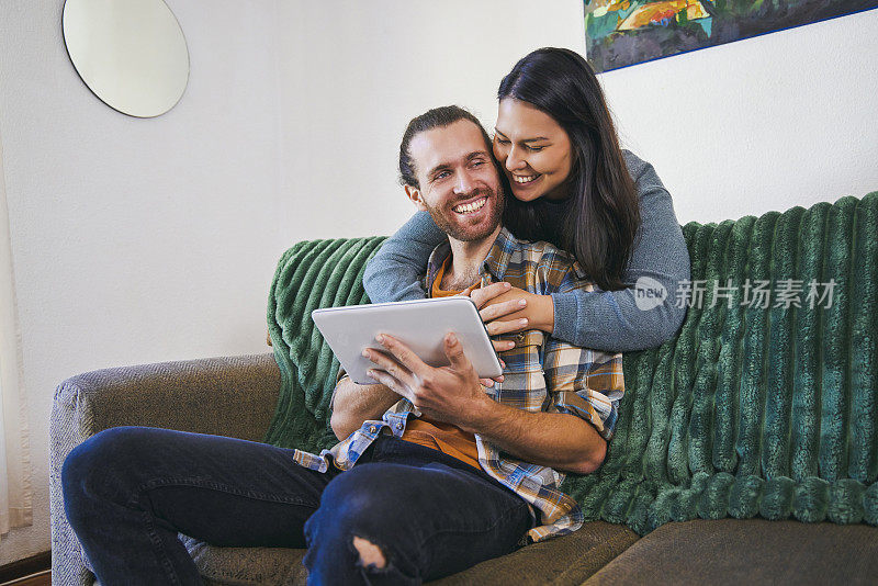 一对年轻夫妇一起使用他们的电子平板电脑