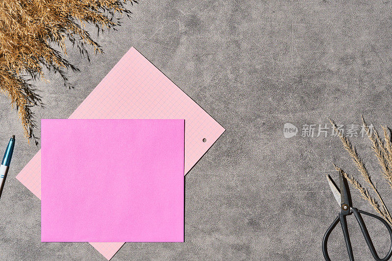 一种空白的布局模板，用紫色信封装邀请或便条，灰色背景，用干草装饰。空白纸卡片在工艺信封，俯视图的信件信封和钢笔