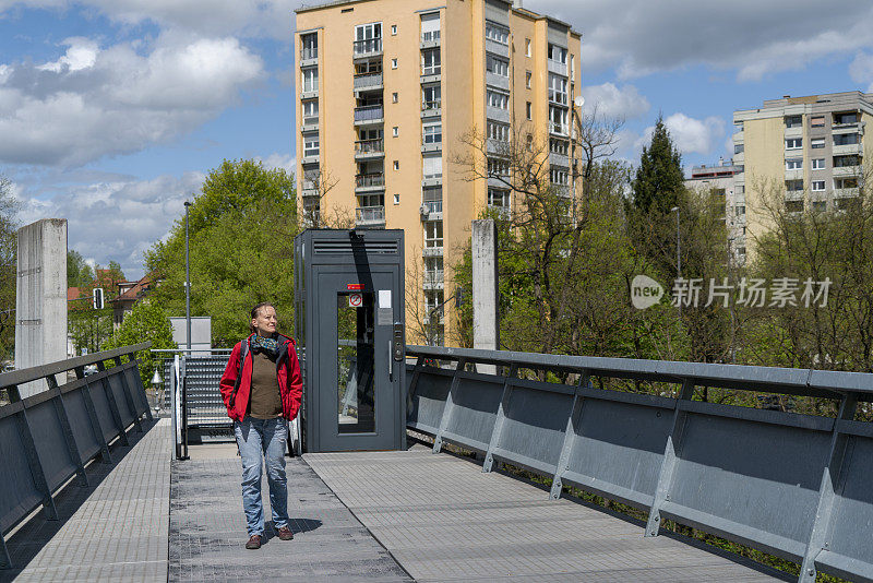 斯洛文尼亚卢布尔雅尼察河上的女子穿过人行天桥