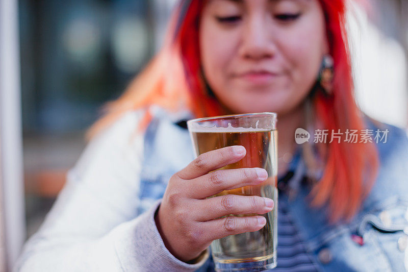 成年女子染头发享受啤酒汉堡和炸薯条