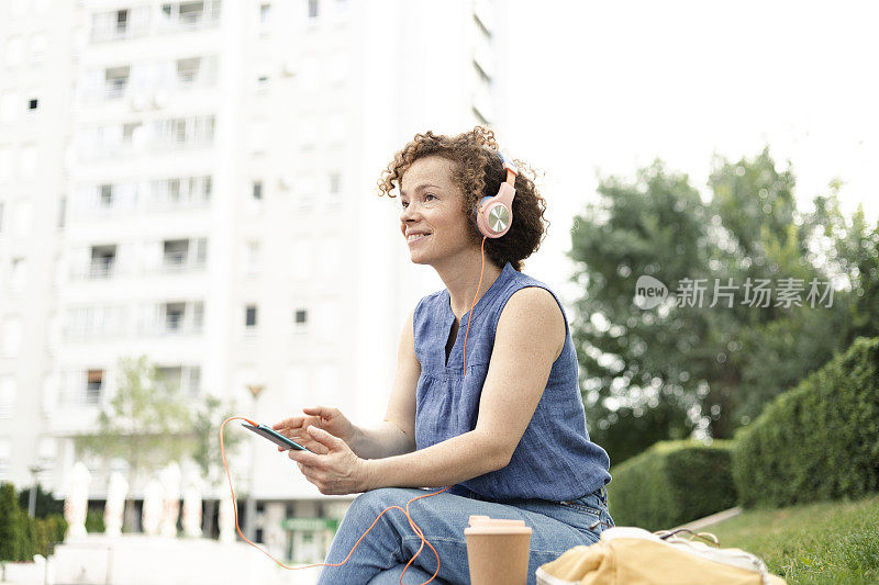 美丽的女孩在户外享受音乐