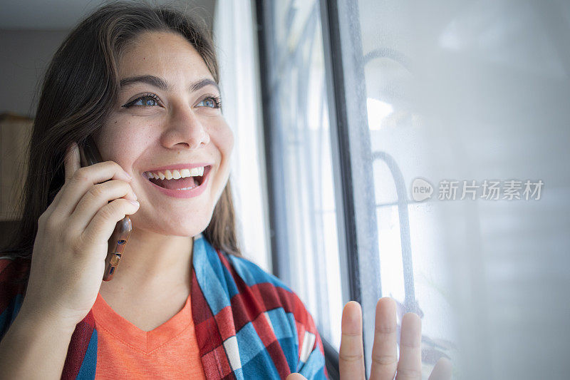 一个女人在家里用手机打电话