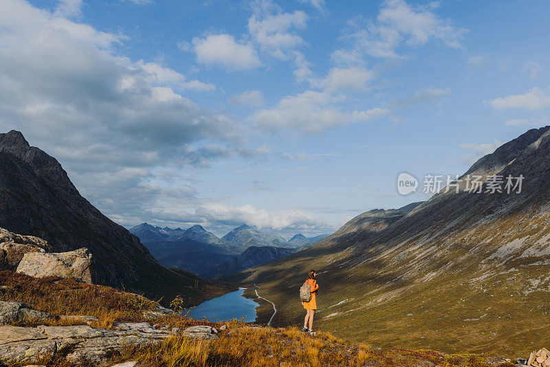 在挪威的秋天，一名徒步旅行者正在思索风景优美的山景