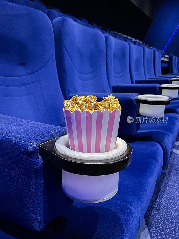 电影影院座位杯托，电影零食食品桶，蓝色天鹅绒座椅，前景的焦点