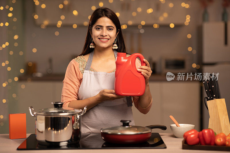 快乐的女人享受做饭在厨房，股票照片