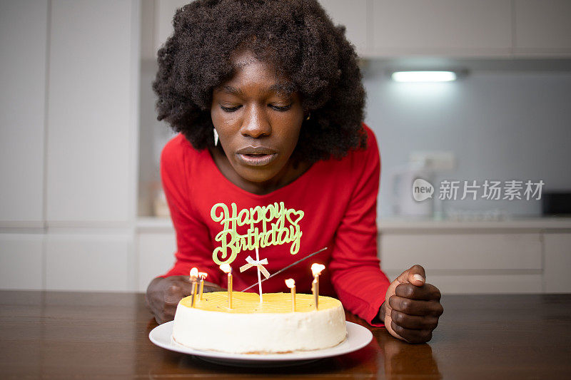 快乐的女士拿着生日蛋糕和蜡烛在家里