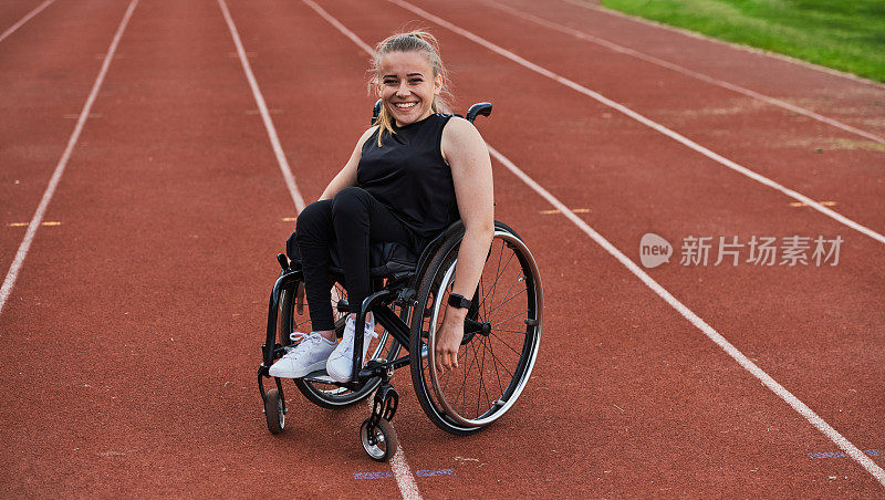 在为残奥会做准备时，在跑道上驾驶轮椅的残疾妇女