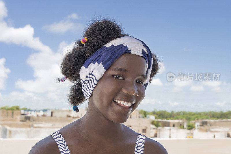 微笑的女孩站在阳台上，非洲发型和辫子，照片