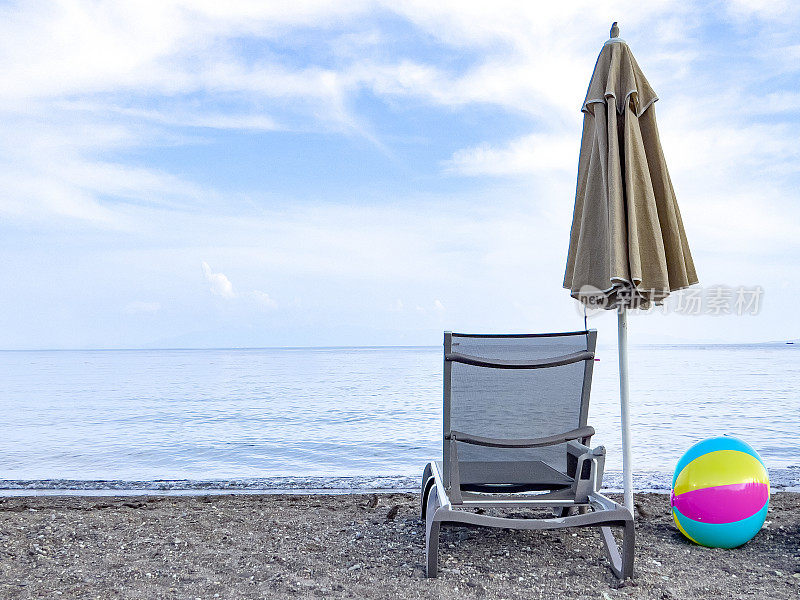 沙滩上的伞、日光浴床和彩球