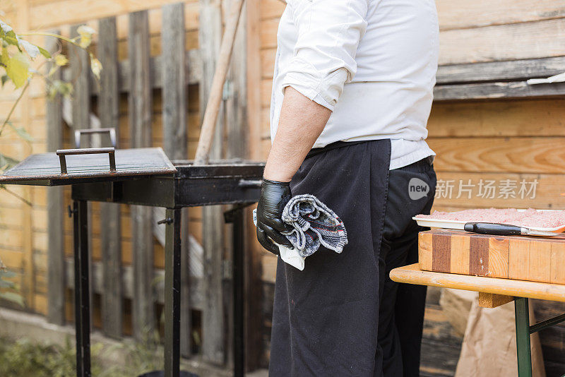厨师用煤和铲子点燃烤架的特写镜头