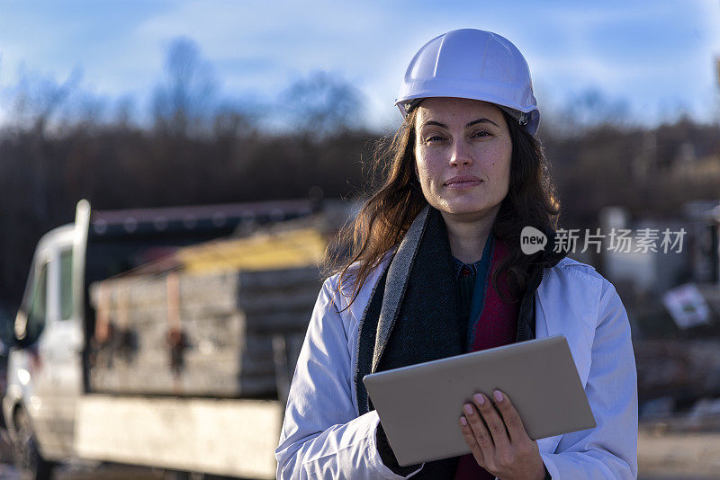 女施工控制工程师用平板检查施工情况。