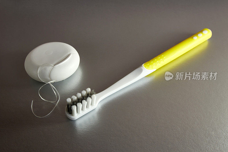 彩色背景上有牙膏和牙线的牙刷。牙科保健。口腔卫生。