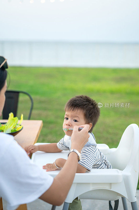 母亲在外面给她的男婴喂食