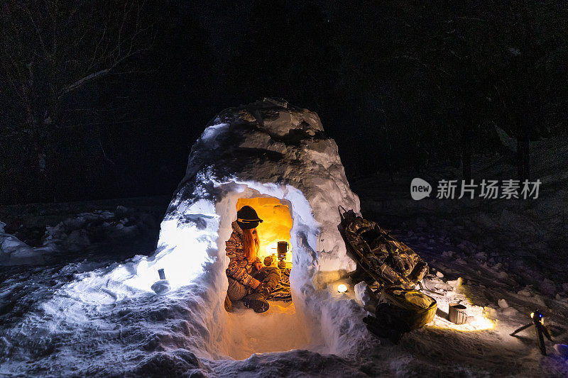 一个女人独自在冬季森林的冰屋里露营