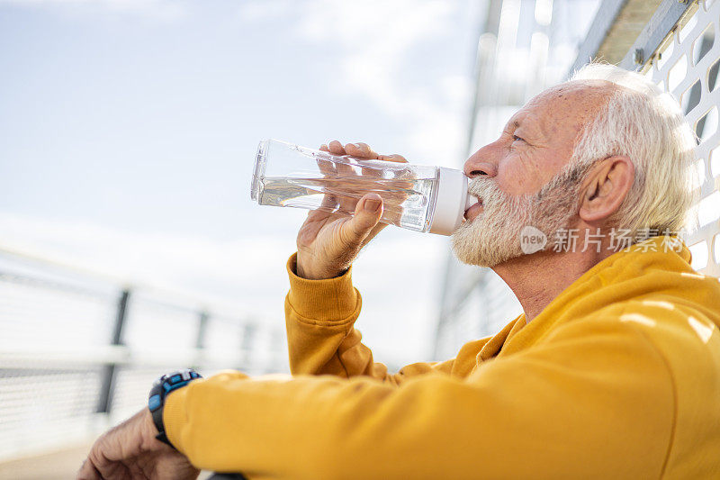 资深运动员在户外运动和喝水后休息