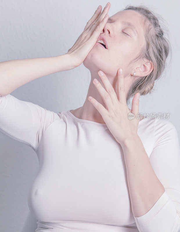 一个美丽的年轻女子抚摸着自己的脸