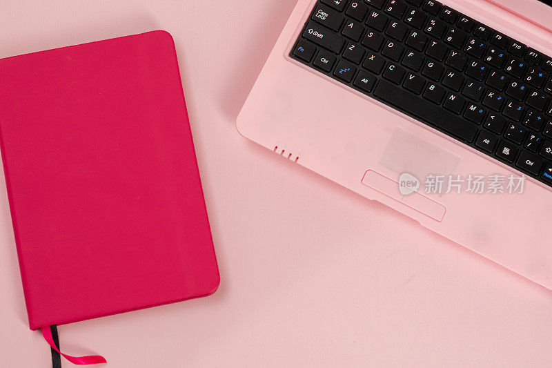 粉色笔记本，粉色背景，女性化的工作场所
