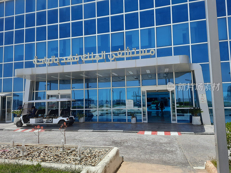 在一个阳光明媚的早晨，Al-Baha的法赫德国王政府医院的入口，灰色的油漆和玻璃面板。