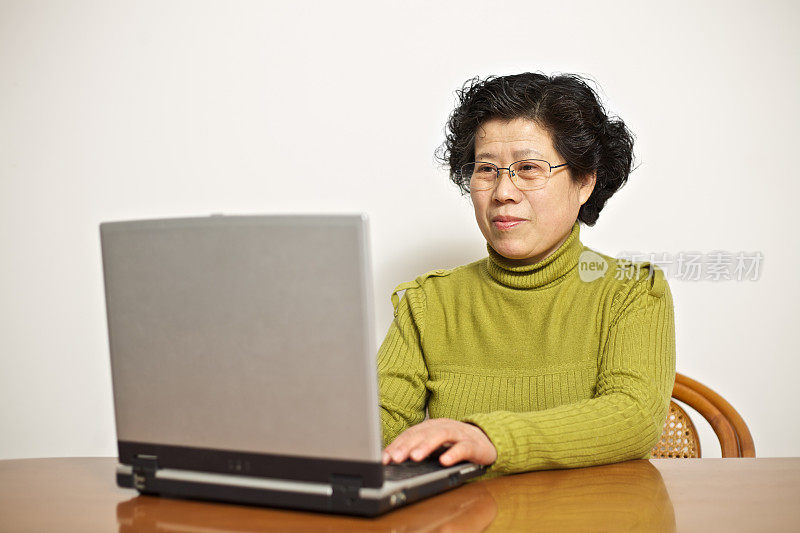成熟的女人在家里使用笔记本电脑