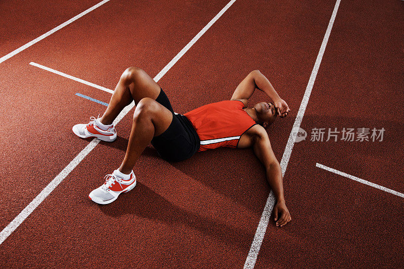 疲惫的运动员躺在跑道上