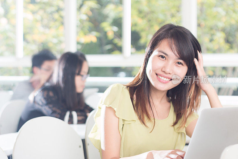 亚洲女孩在教室里用笔记本学习