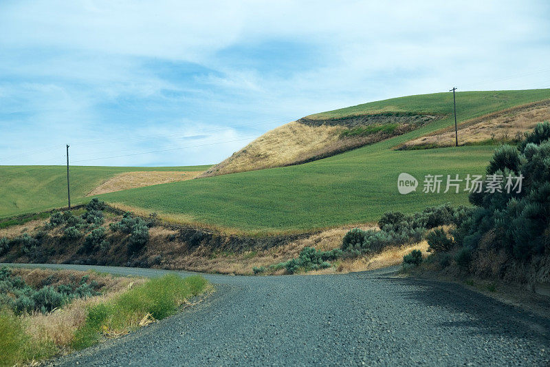 碎石路穿过乡村景观，农田上的山丘