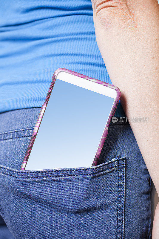 智能手机特写在女人的牛仔裤口袋。