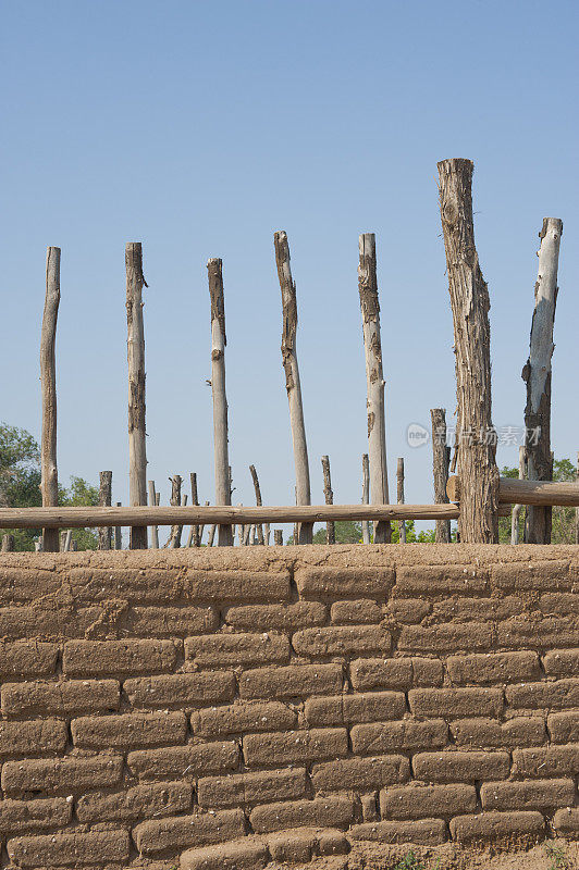 老土坯砖墙和木棍栅栏
