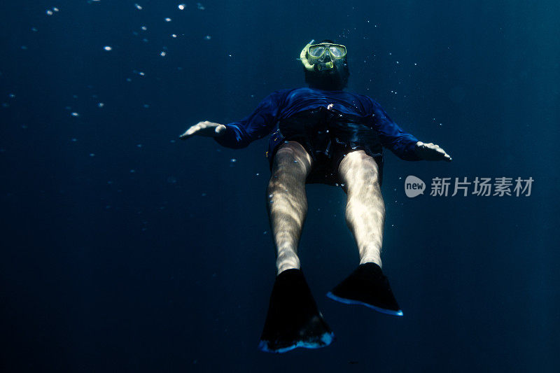 一个成年人在水下浮潜。