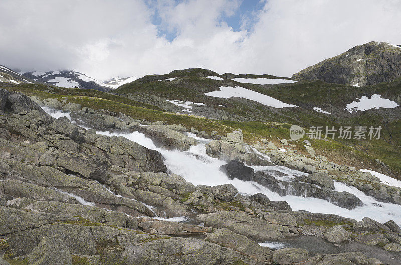 在Jotunheimen山上的碎石和巨石之间的瀑布