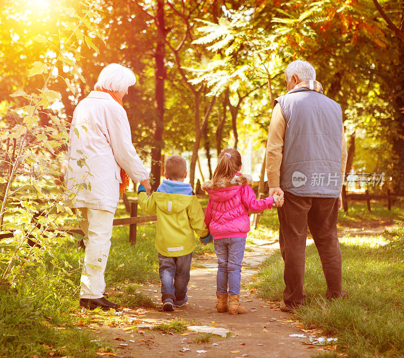 祖父母带着孙子孙女在公园散步。
