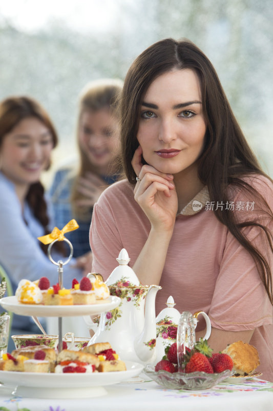 年轻漂亮的女人正在喝下午茶