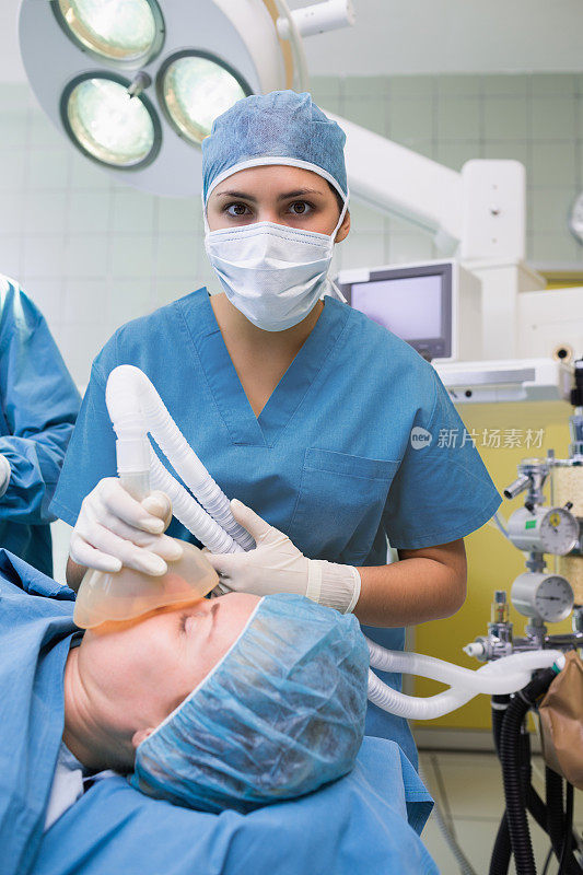 女性麻醉师拿着一个口罩在病人脸上