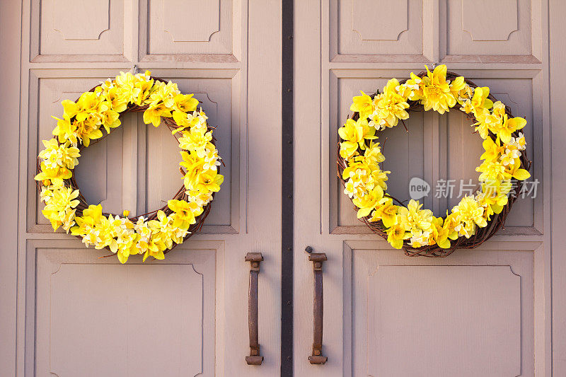 一对漂亮的黄色花环在棕黄色的门上