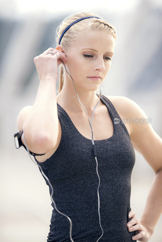 年轻的成年女性戴着耳塞听音乐