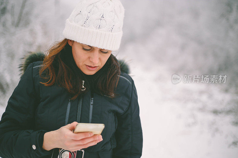 年轻美丽的黑发女子在一个下雪天打电话