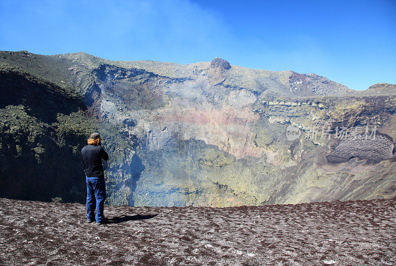 一名男子站在智利维拉里卡火山冒烟的火山口附近