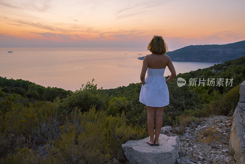 女人站在岩石上欣赏海景