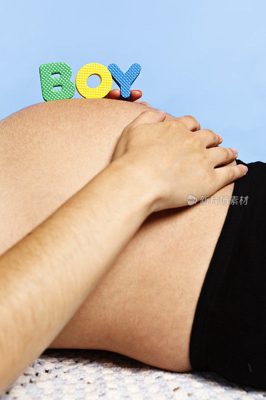 男孩字母在怀孕的肚子上