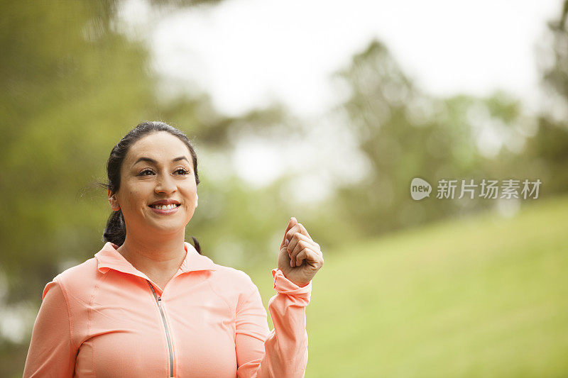 一位拉丁裔妇女在附近的公园里跑步。