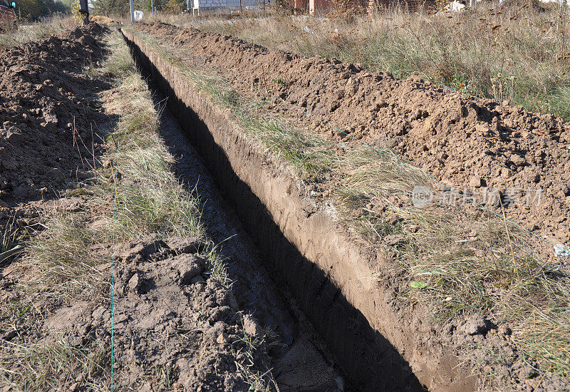 土方工程,挖战壕。为铺设管道或光纤而挖的长土沟。挖沟。