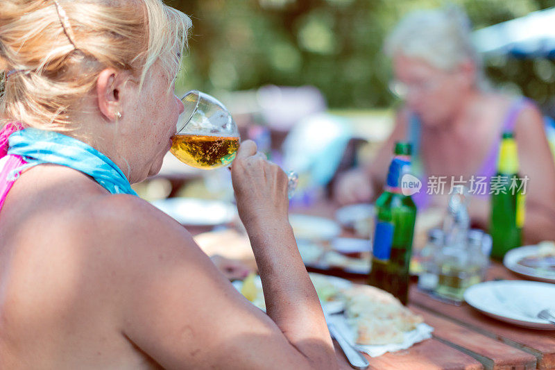 老年妇女喝啤酒