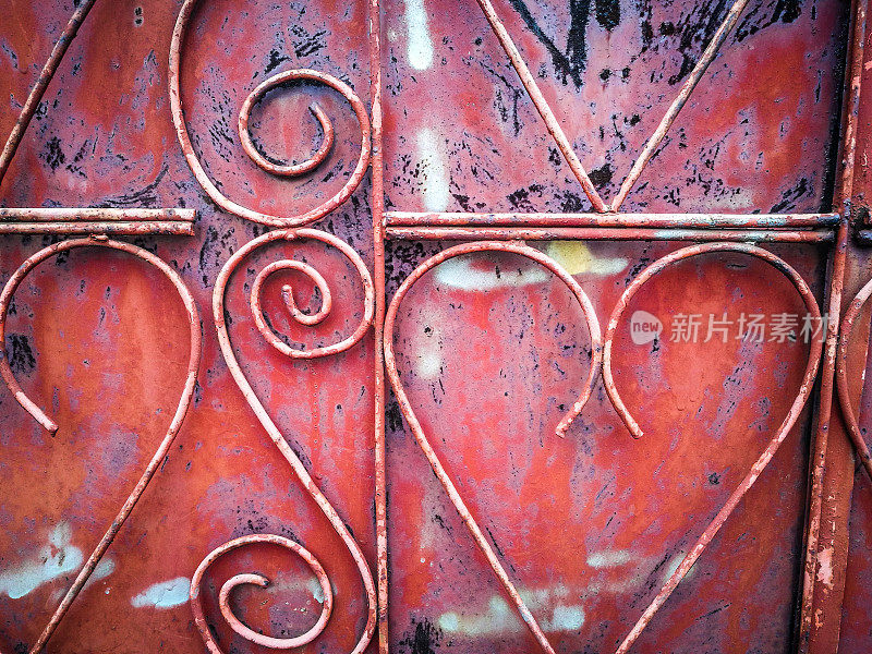 锈迹斑斑的红色金属铁栅栏呈心形排成一排